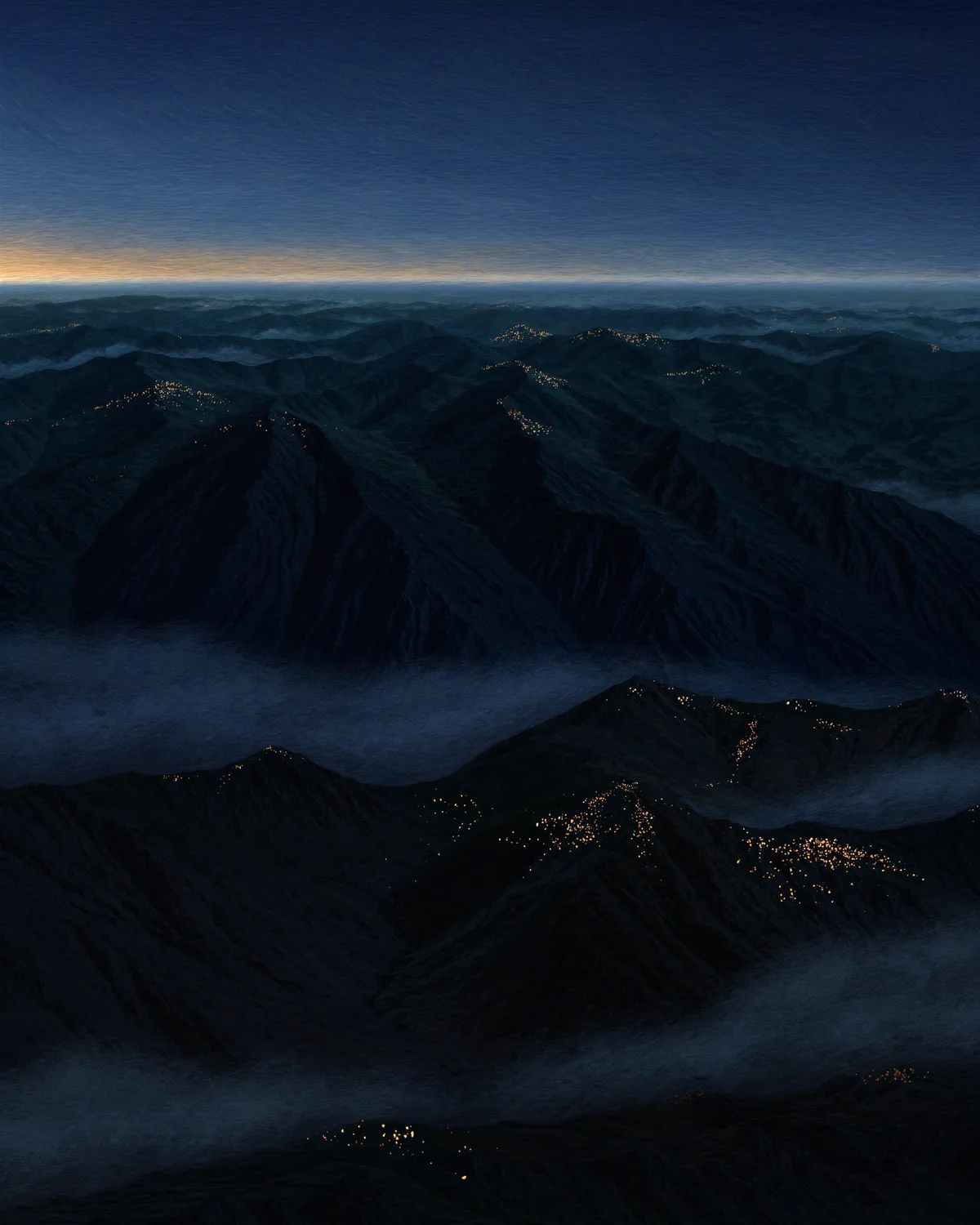 Warm points of light scattered across a mountain range at nightfall